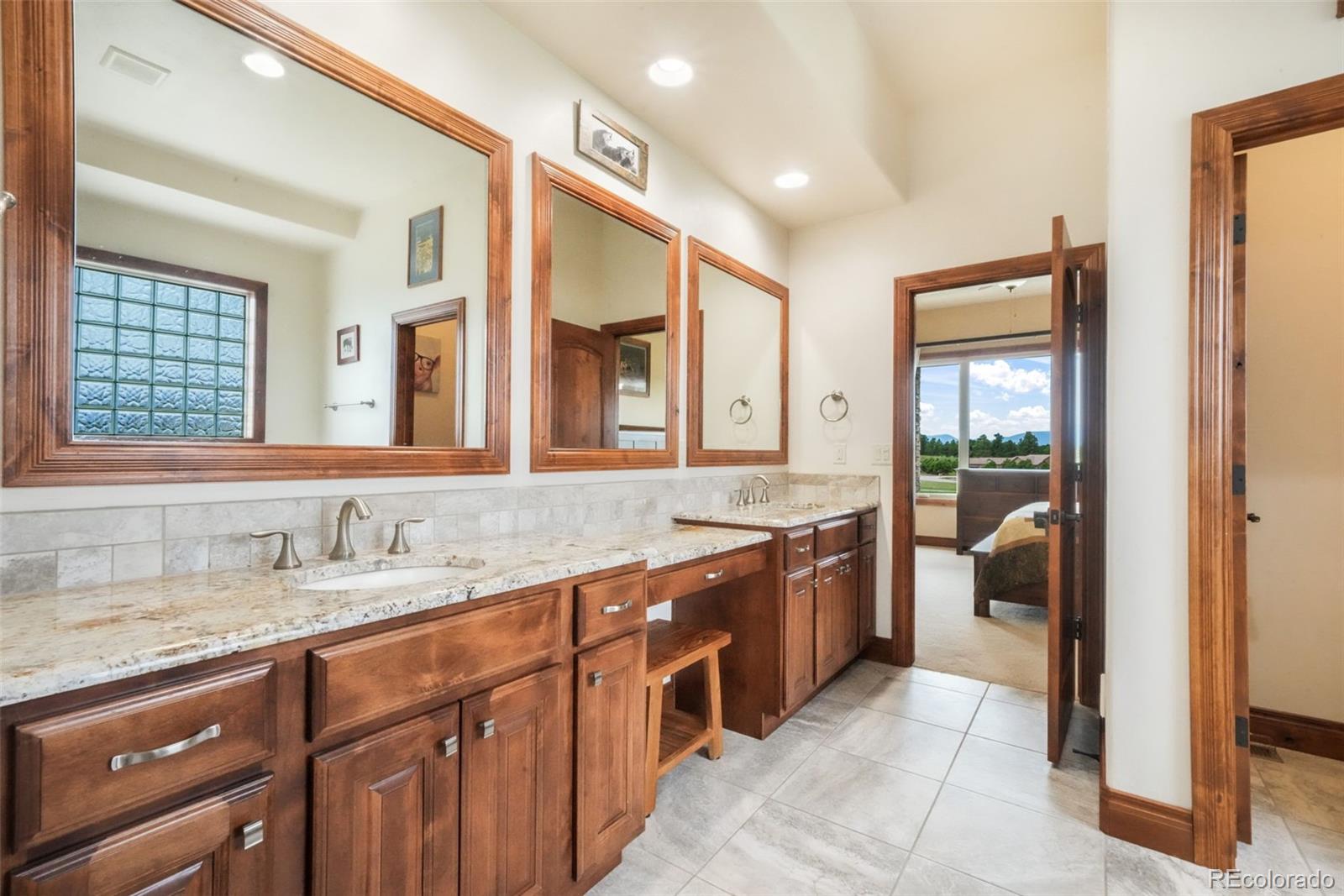 4330 Settlers Ranch Road Colorado Springs, CO 80908 - Photo 22 of 50 a large bathroom with a granite countertop sink and a large mirror