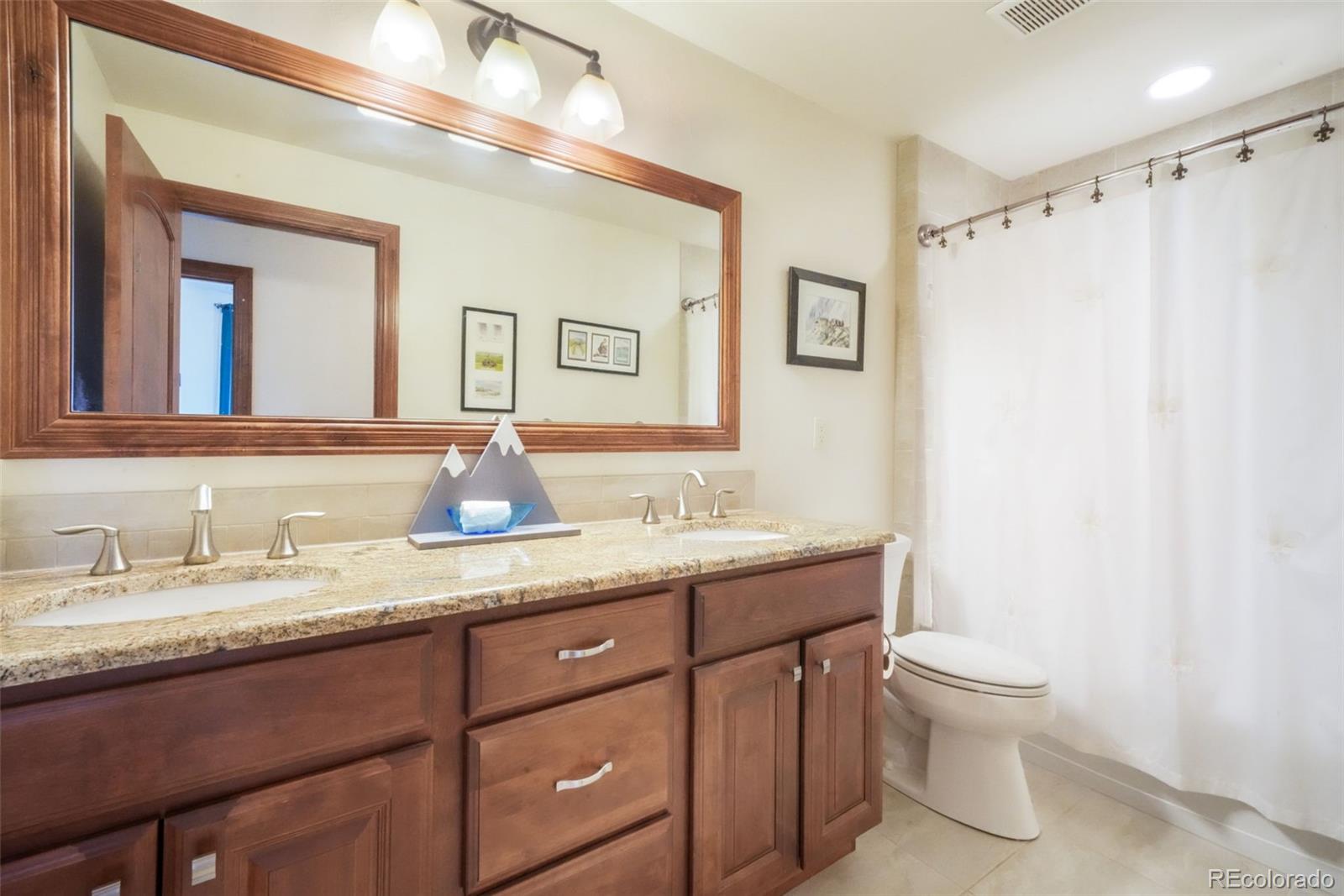 4330 Settlers Ranch Road Colorado Springs, CO 80908 - Photo 41 of 50 a bathroom with a granite countertop sink toilet a large mirror and shower