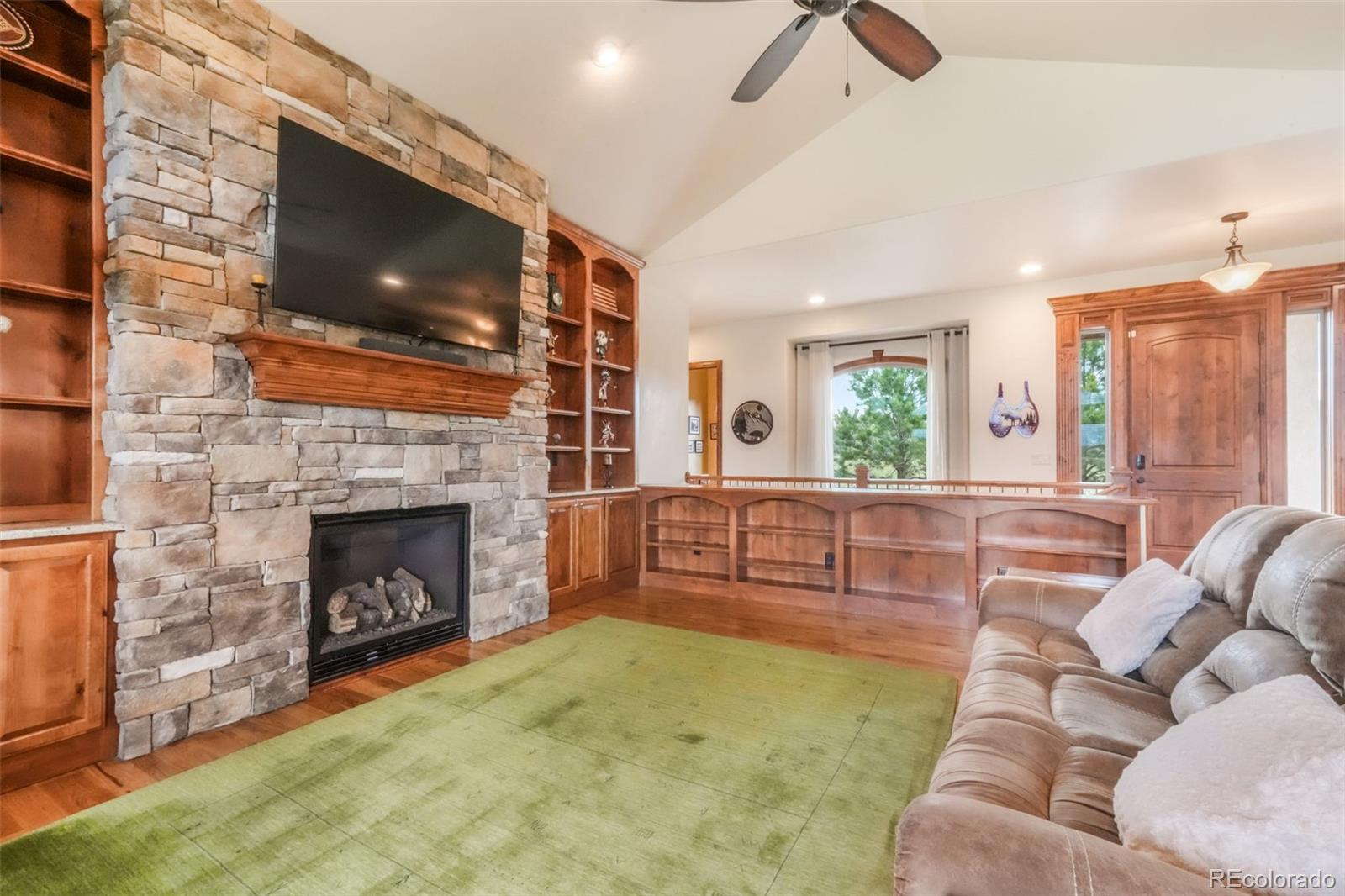 4330 Settlers Ranch Road Colorado Springs, CO 80908 - Photo 7 of 50 a living room with furniture a flat screen tv and a fireplace