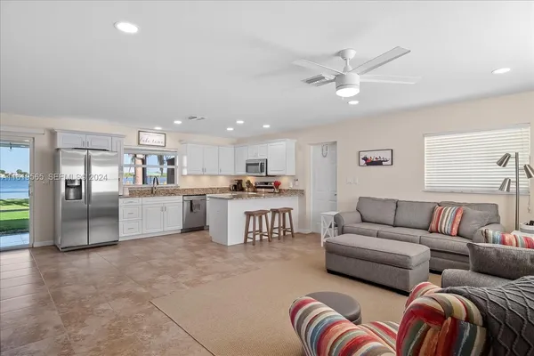 a living room with furniture and kitchen view