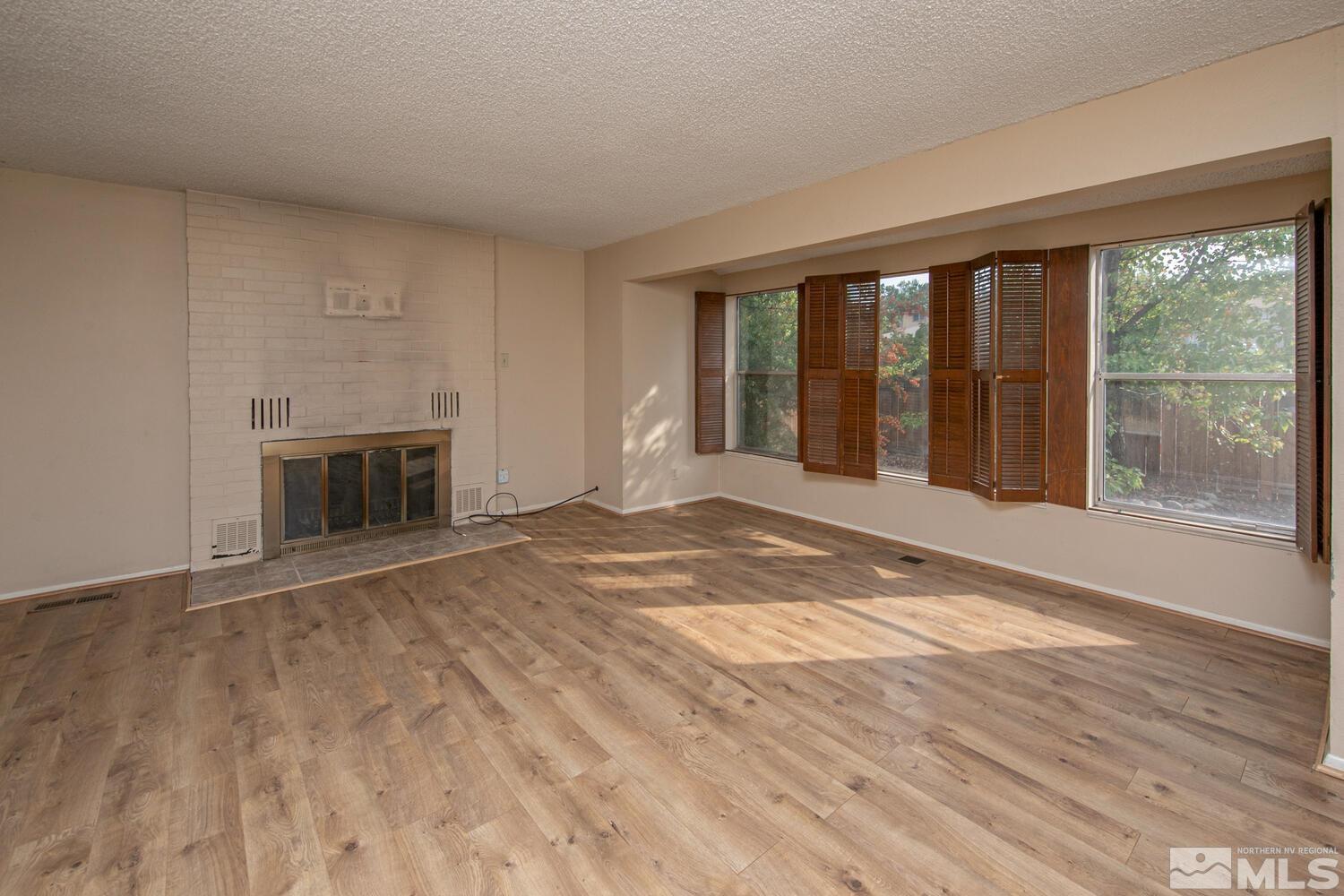 1675 Kings Row Reno, NV 89503 - Photo 7 of 32 a view of an empty room with a window and wooden floor