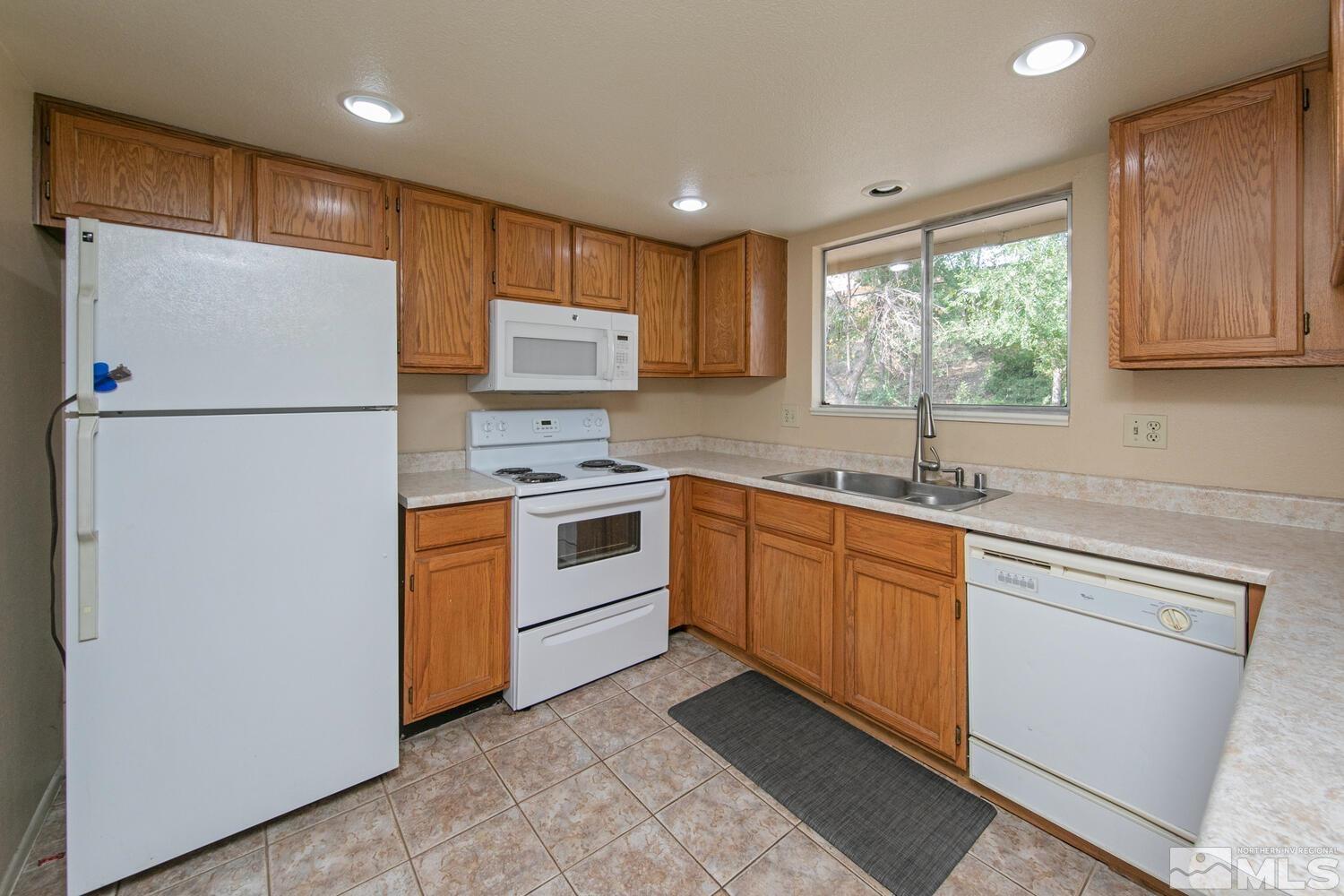 1675 Kings Row Reno, NV 89503 - Photo 10 of 32 a kitchen with white cabinets and white appliances