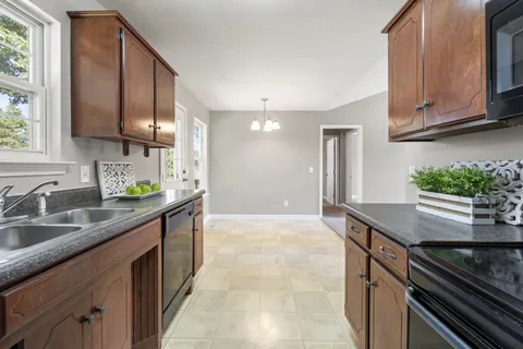 a kitchen with stainless steel appliances granite countertop a sink stove and cabinets