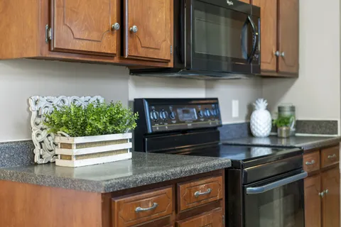 a kitchen with granite countertop a stove and cabinets