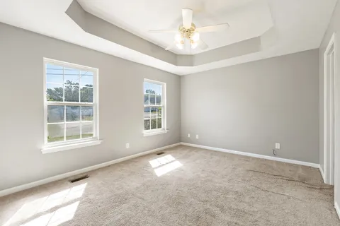 an empty room with windows and fan