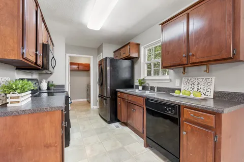 a kitchen with stainless steel appliances granite countertop a refrigerator a stove a sink and dishwasher