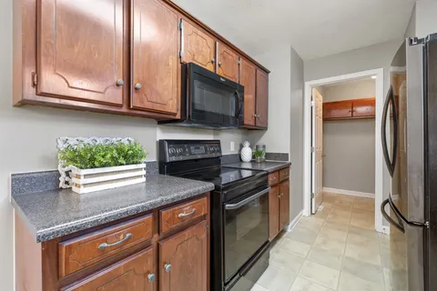 a kitchen with stainless steel appliances granite countertop a stove microwave and cabinets