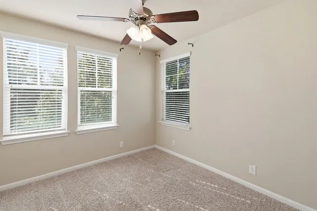 an empty room with a window and a fan