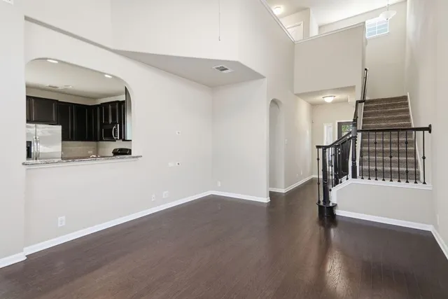 a view of a hallway with wooden floor and staircase