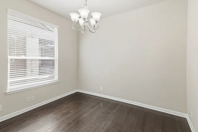 a view of a room with wooden floor and a window