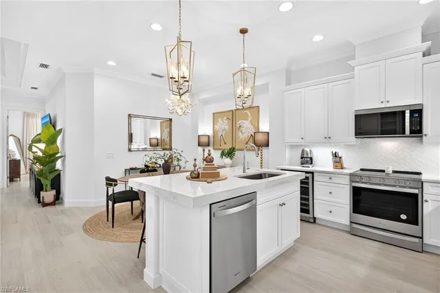 a kitchen with a sink a stove and chairs