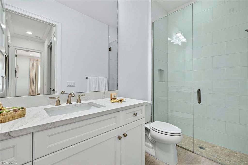8877 Yucatan Court Naples, FL 34113 - Photo 23 of 29 a bathroom with a toilet a sink a mirror a shower a vanity and window