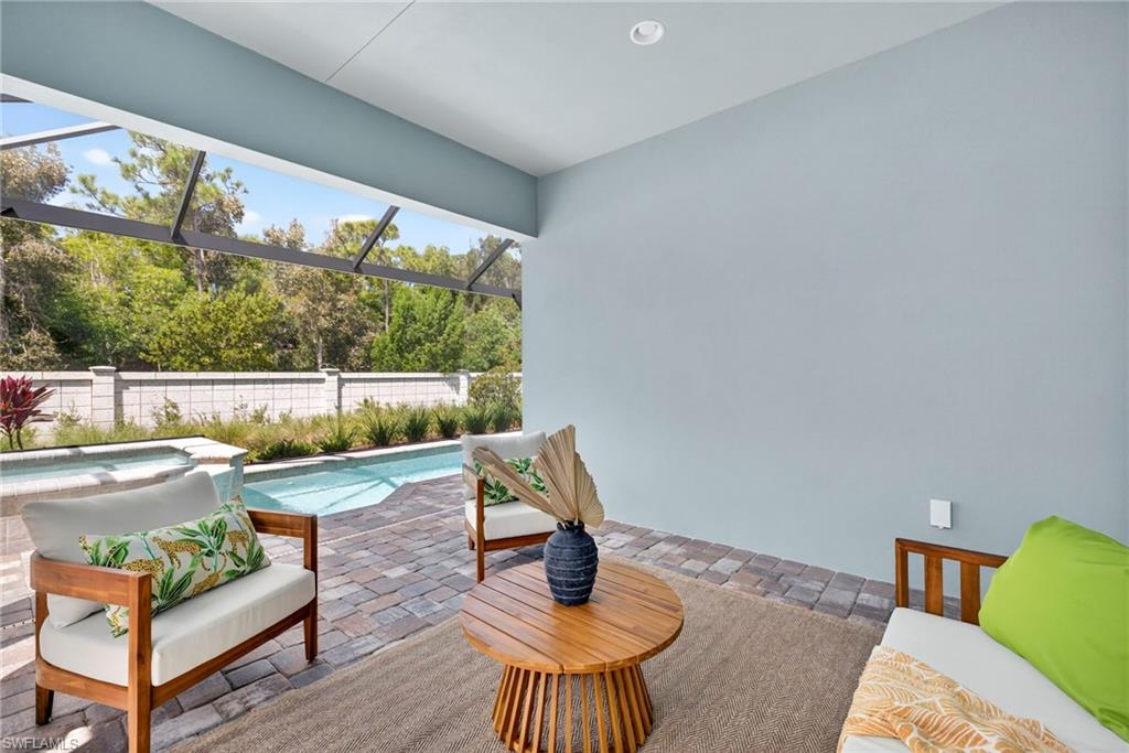 8877 Yucatan Court Naples, FL 34113 - Photo 26 of 29 a living room with furniture and a floor to ceiling window