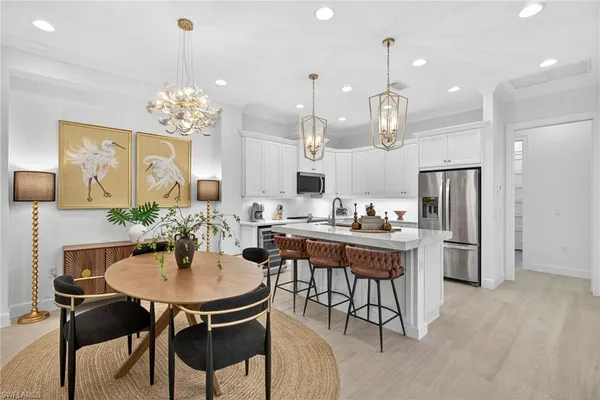 a kitchen with kitchen island a dining table and chairs