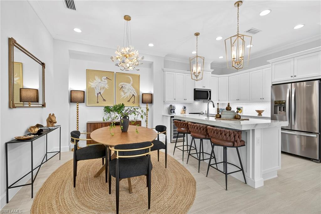 8877 Yucatan Court Naples, FL 34113 - Photo 9 of 29 a view of a dining room with furniture a chandelier and wooden floor