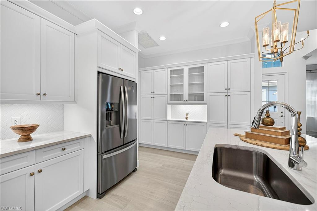 8877 Yucatan Court Naples, FL 34113 - Photo 10 of 29 a kitchen with a refrigerator sink and cabinets