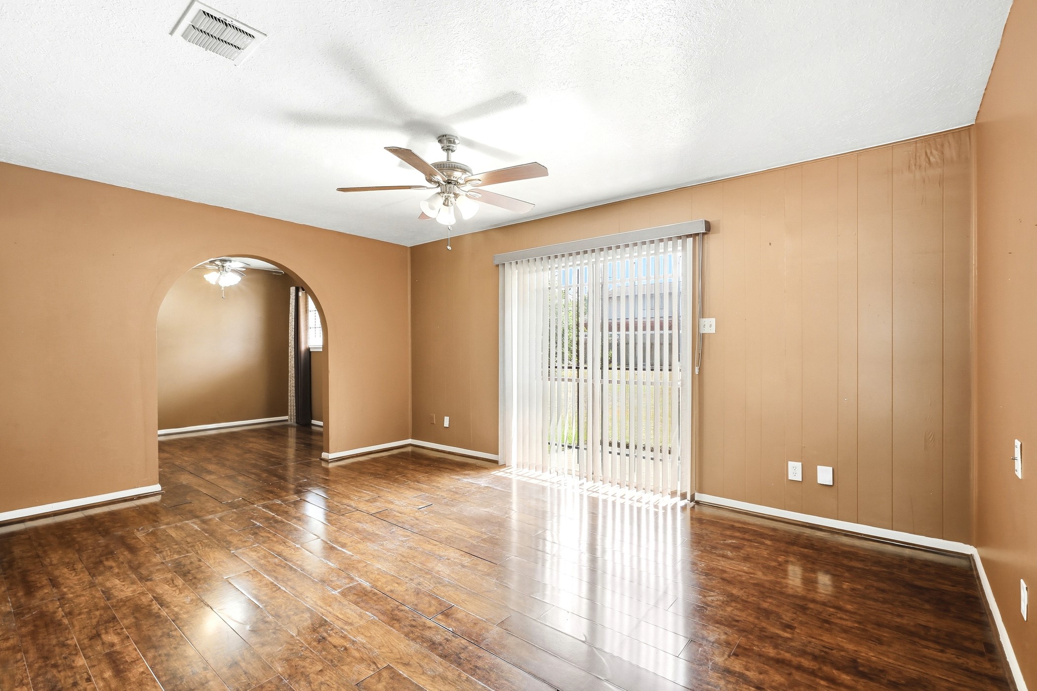 1507 Willow Rock Road Houston, TX 77088 - Photo 12 of 27 Living room with a graceful arched doorway and sliding glass door bringing in natural light from the backyard.