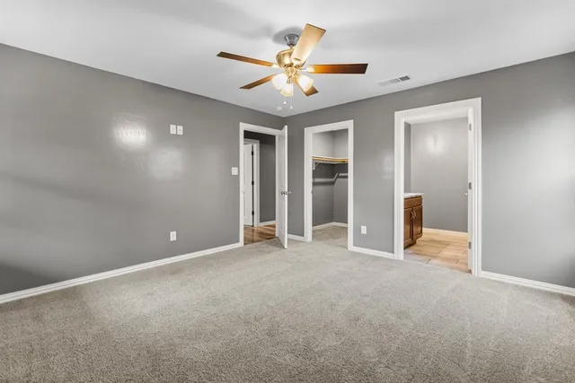 a view of an empty room with a ceiling fan