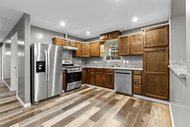 a kitchen with stainless steel appliances a refrigerator sink and cabinets
