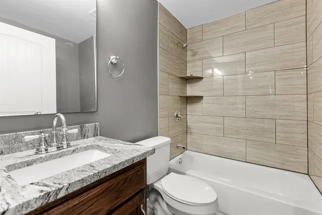 a bathroom with a granite countertop sink toilet and shower