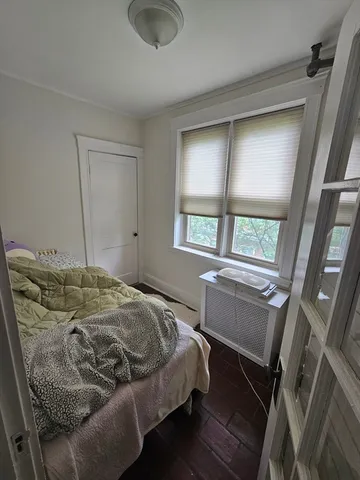 a bed sitting in a bedroom next to a window