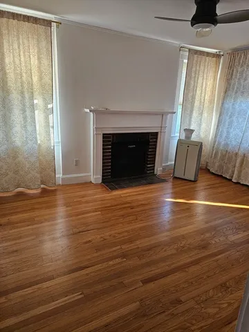 an empty room with wooden floor and fireplace