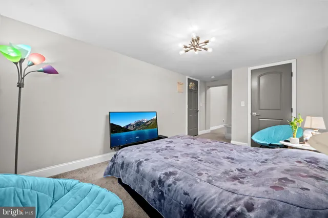 a bedroom with a bed and a chandelier