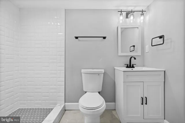 a bathroom with a toilet a sink and mirror