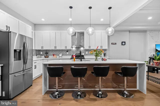 a kitchen with a refrigerator a sink and chairs