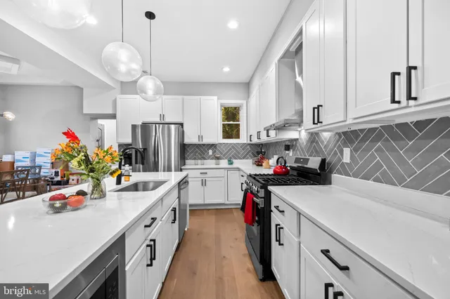 a kitchen that has a lot of cabinets and wooden floor