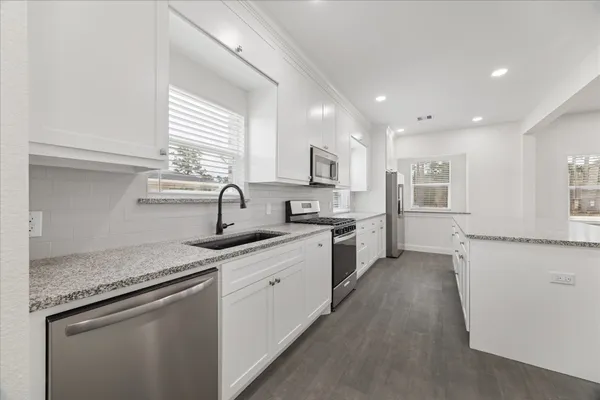 a kitchen with counter top space and windows