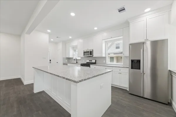 a kitchen with stainless steel appliances cabinets a sink and a refrigerator