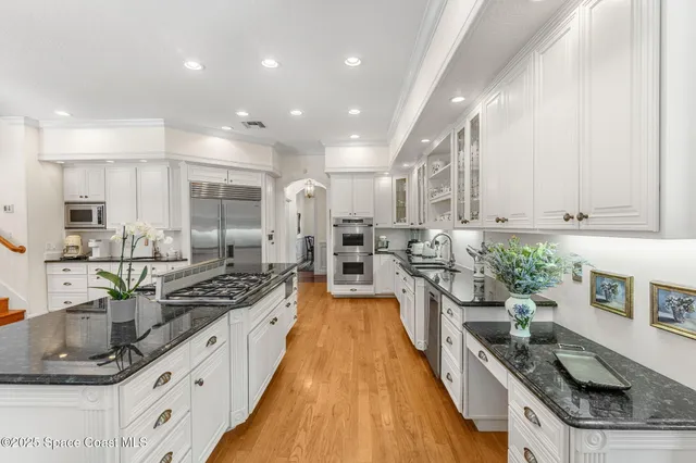 a large kitchen with stainless steel appliances lots of counter space and a sink