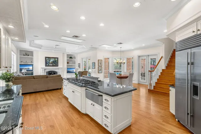 a kitchen with stainless steel appliances granite countertop a stove and a living room