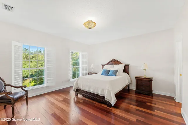 a view of a hallway with wooden floor and windows