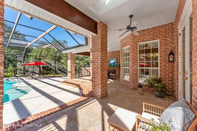 a view of a swimming pool with lawn chairs under an umbrella