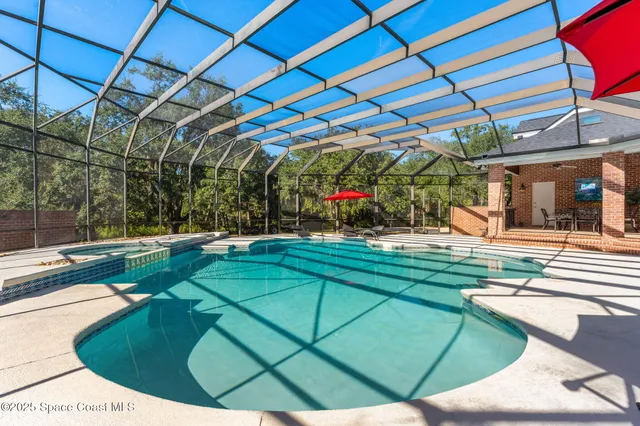 a view of a backyard with table and chairs under an umbrella