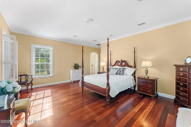 a bedroom with a bed and wooden floor