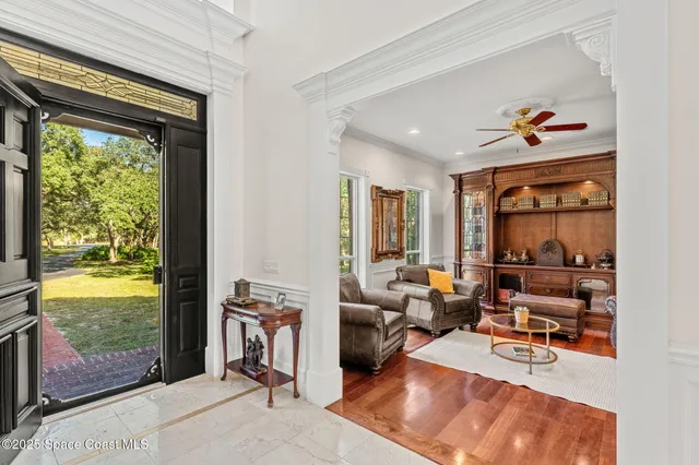 a living room with furniture a floor to ceiling window and a flat screen tv