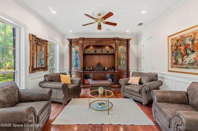 a living room with furniture a large window and a chandelier