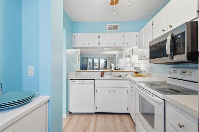 a kitchen with stainless steel appliances a white stove top oven sink and cabinets