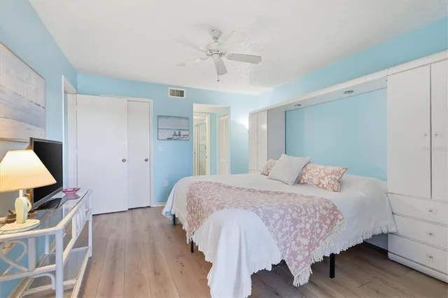 a bedroom with a bed and wooden floor