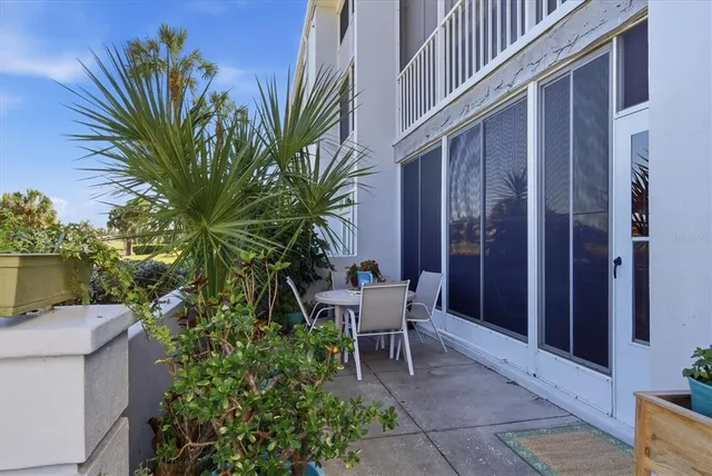 a view of a chair and table in the porch with potted plants