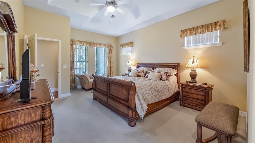 10336 Lake Louisa Road Clermont, FL 34711 - Photo 23 of 62 a bedroom with a bed chair and a flat tv screen on a dresser