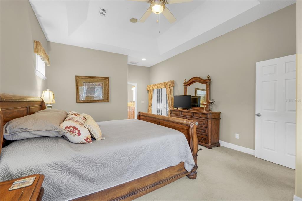 10336 Lake Louisa Road Clermont, FL 34711 - Photo 26 of 58 a bedroom with a large bed and a lamp