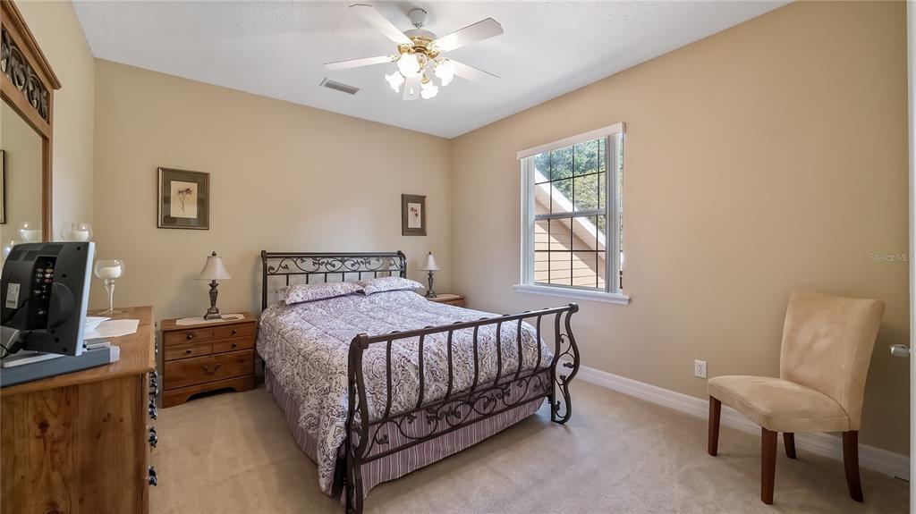 10336 Lake Louisa Road Clermont, FL 34711 - Photo 29 of 62 a bedroom with a bed chairs and a window