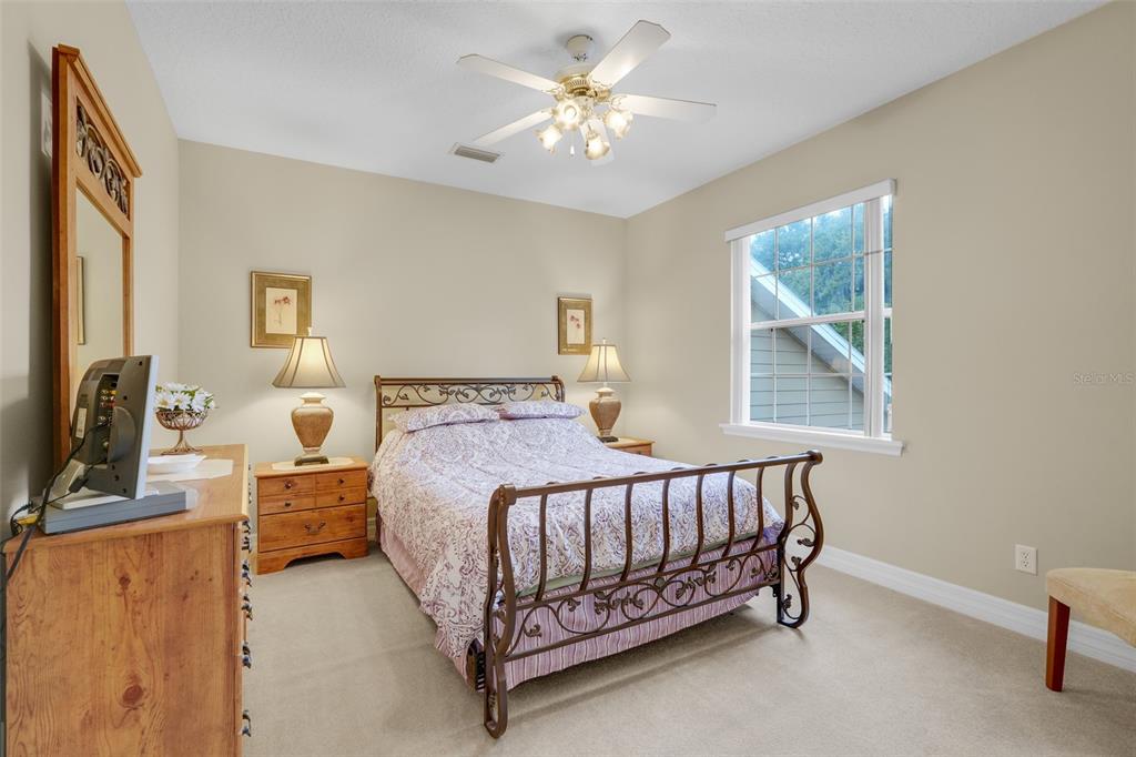 10336 Lake Louisa Road Clermont, FL 34711 - Photo 33 of 58 a bedroom with a bed and a chandelier