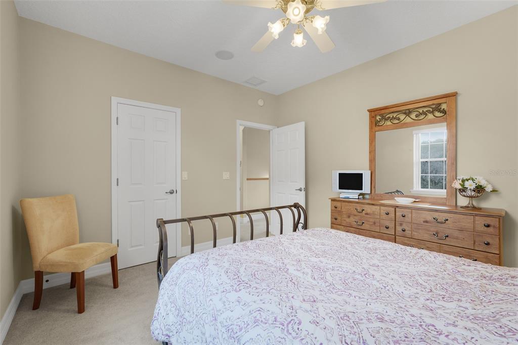 10336 Lake Louisa Road Clermont, FL 34711 - Photo 34 of 58 a spacious bedroom with a bed and a chair