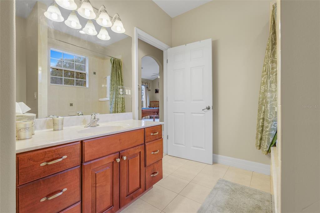10336 Lake Louisa Road Clermont, FL 34711 - Photo 36 of 58 a spacious bathroom with a granite countertop sink a mirror and a shower