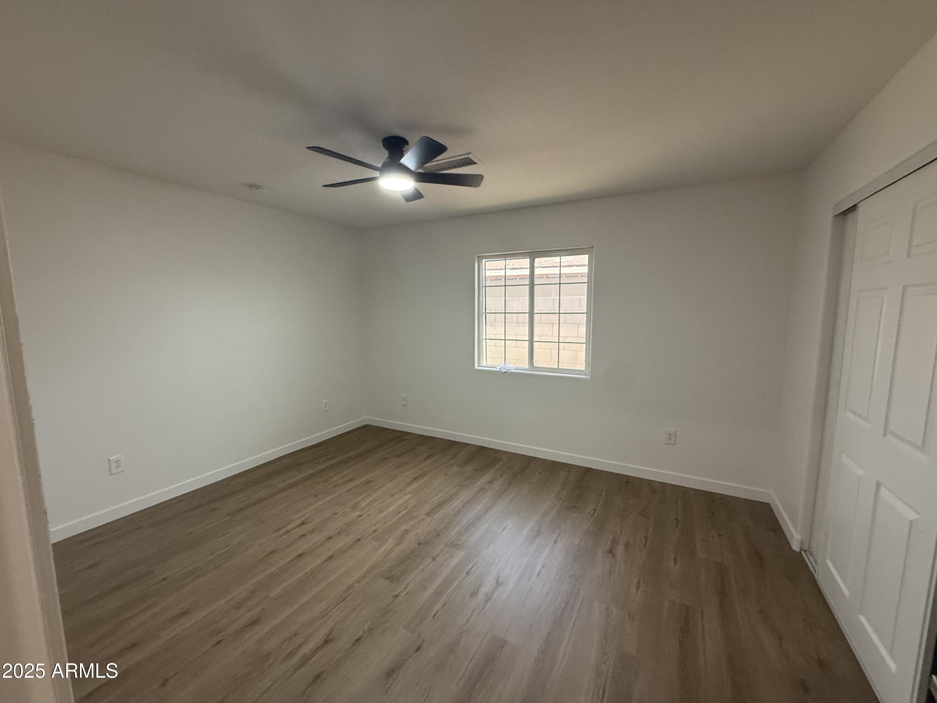 2702 East Juniper Avenue Phoenix, AZ 85032 - Photo 16 of 19 a view of empty room with wooden floor and fan